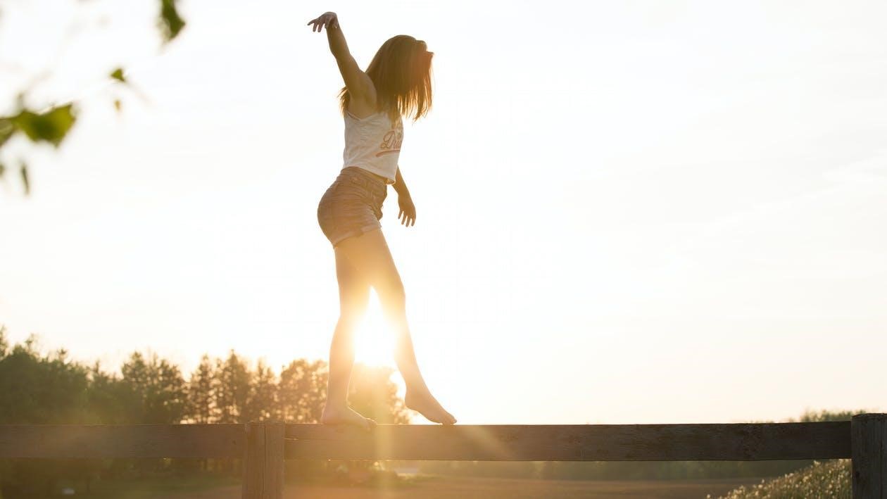 Woman balancing herself on the fence