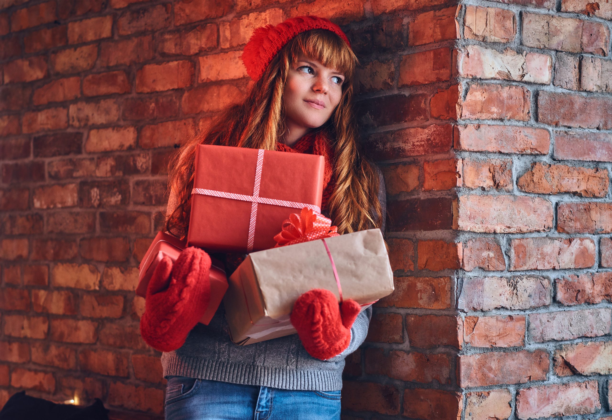 Redhead female holds Christmas gift.