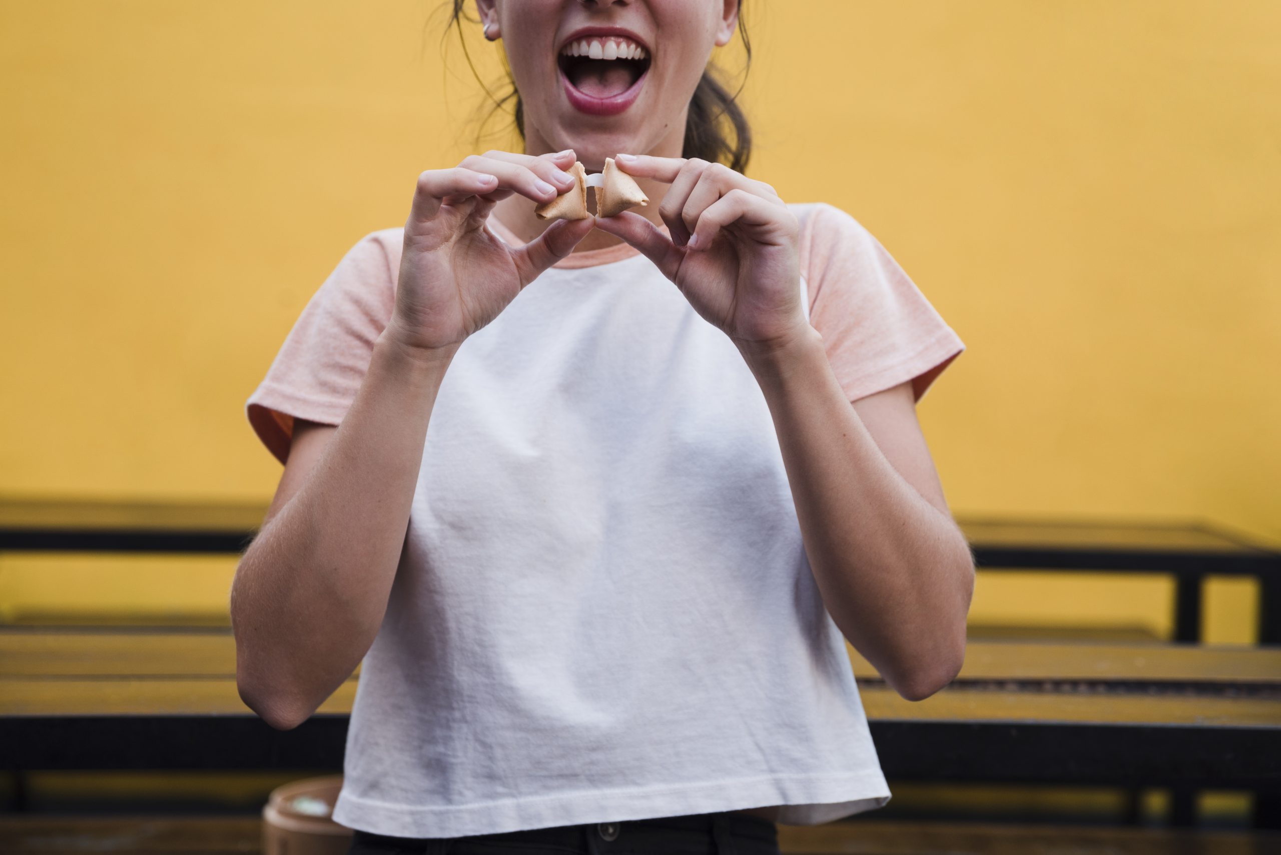 young woman opening fortune cookie